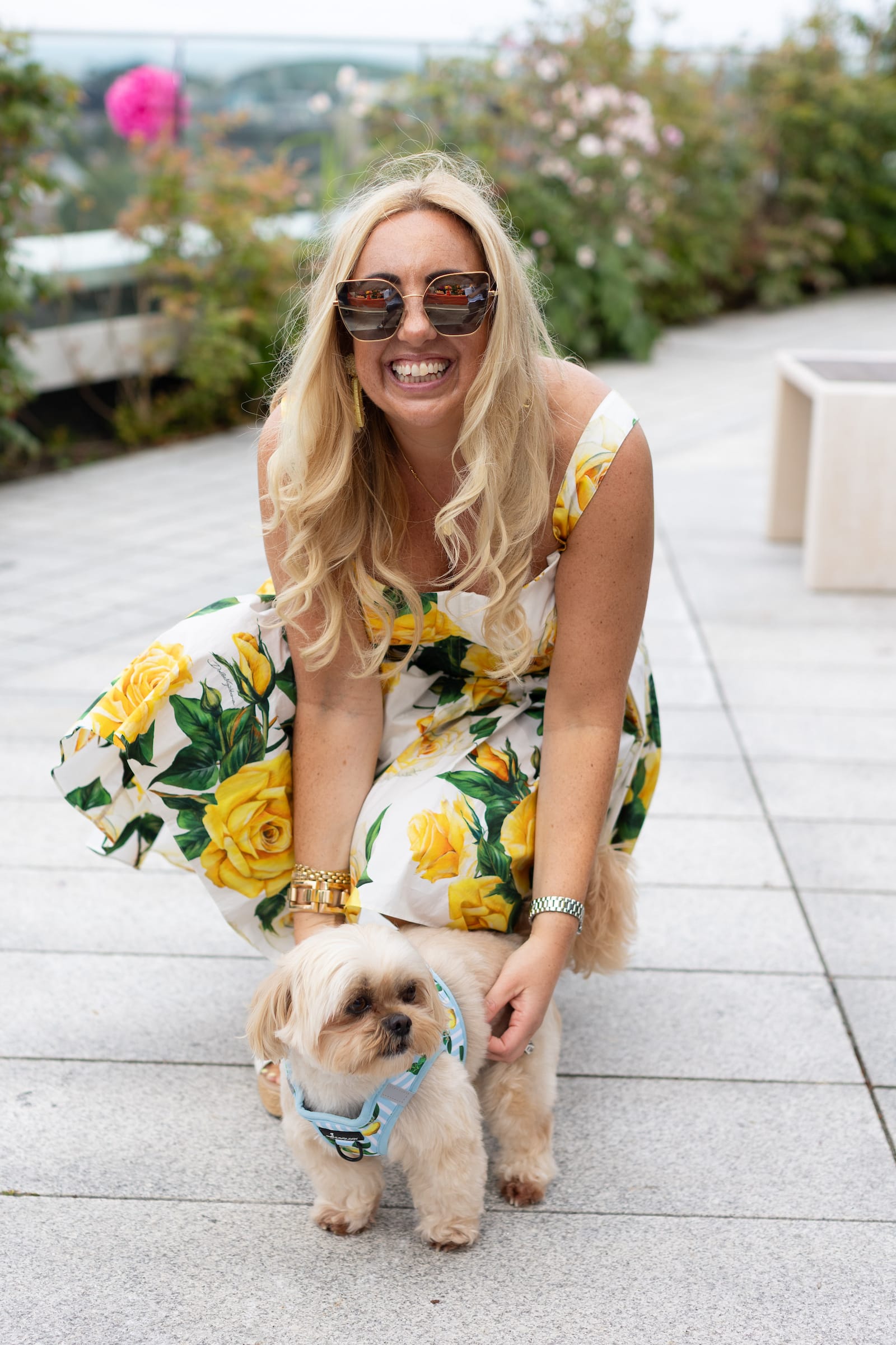 Katie smiling on a rooftop terrace with her Shih Tzu, Biscuit